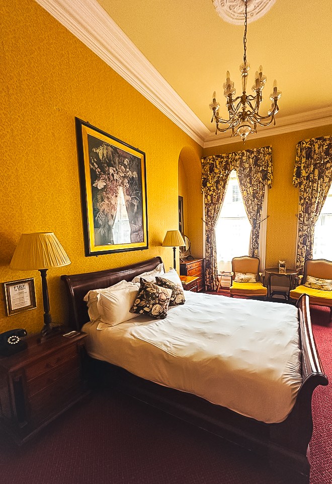 A warm yellow guest room at The Kennard in Bath